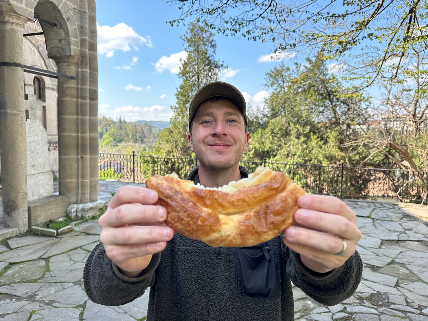 Callum enjoying a traditional Bulgarian banitsa pastry, a tasty and affordable treat in Veliko Tarnovo
